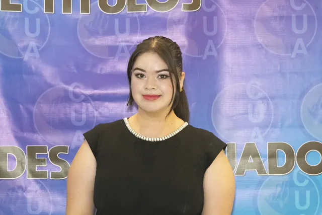 Retrato de una graduada con vestido negro frente al fondo de la ceremonia. Graduación del 7 de julio de 2025.