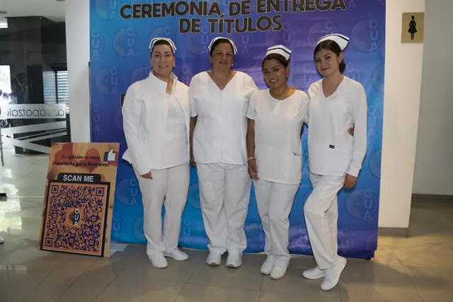 Cuatro participantes con uniformes blancos posan juntos. Graduación del 7 de julio de 2025.