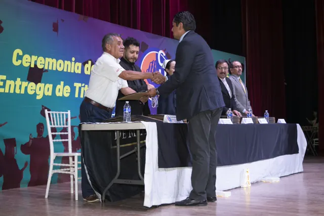 Graduado saluda a las autoridades durante la entrega. Graduación del 7 de julio de 2025.