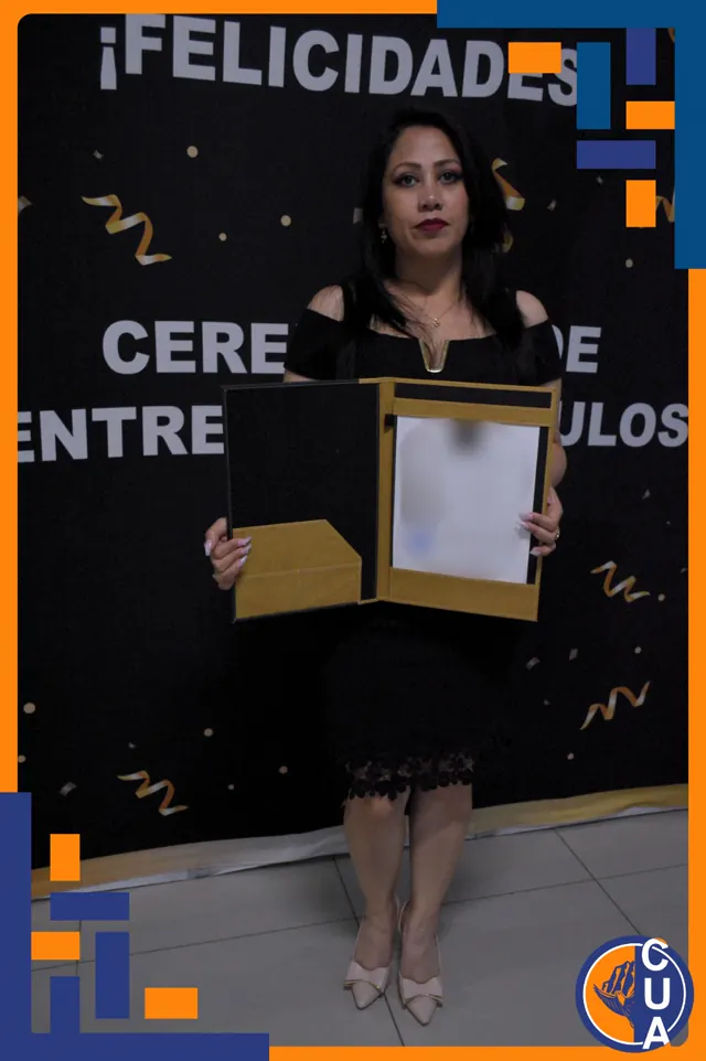 Egresada con vestido negro sostiene una carpeta de titulación frente al letrero de felicitación.
