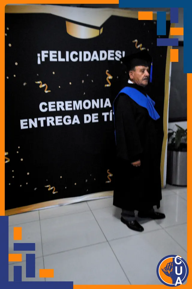 Graduado de pie con toga negra, birrete y estola azul frente al fondo de la ceremonia.