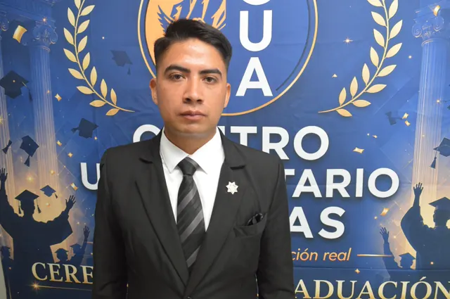 Retrato de un participante con traje negro y corbata gris ante el fondo de la ceremonia.