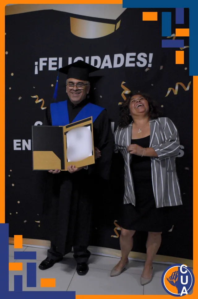Graduado y acompañante sonríen junto al reconocimiento. Graduación del 14 de junio de 2025.